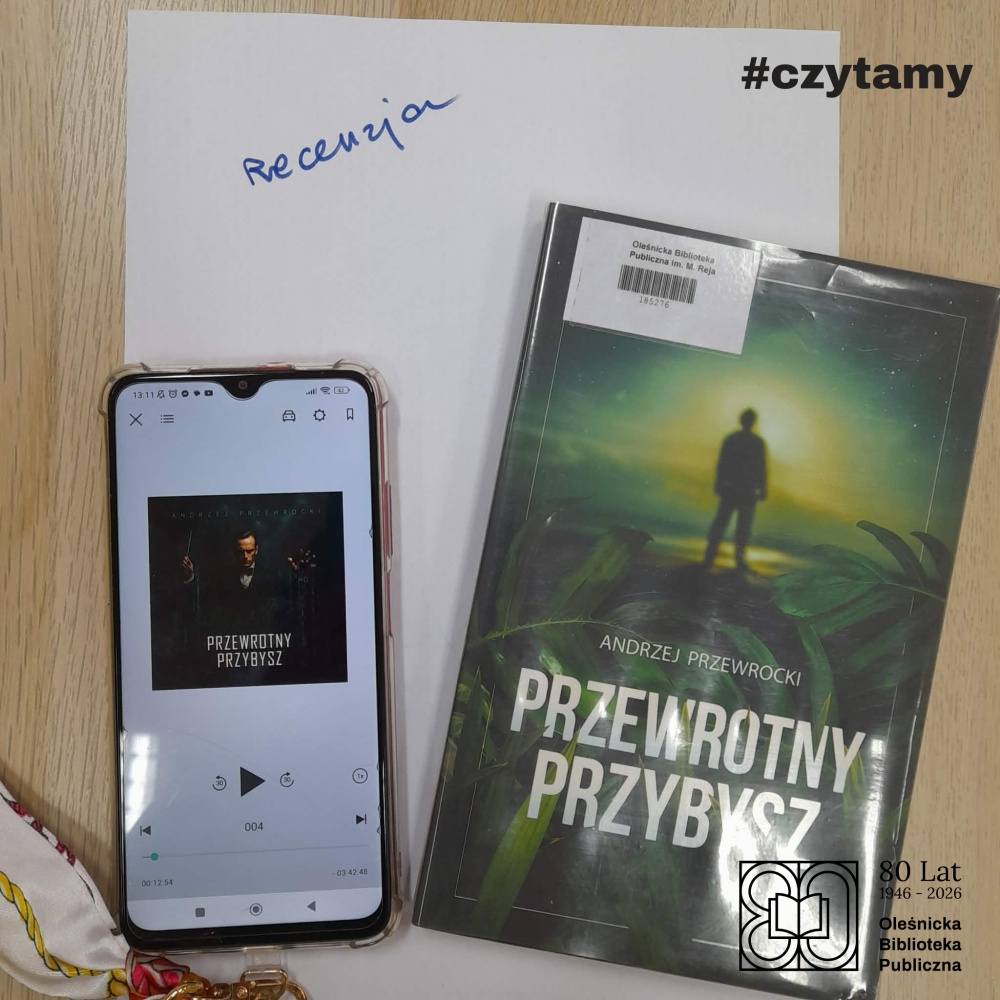 Okładka książki "Przewrotny przybysz w wersji papierowej oraz jako okładka audiobooka na smartfonie