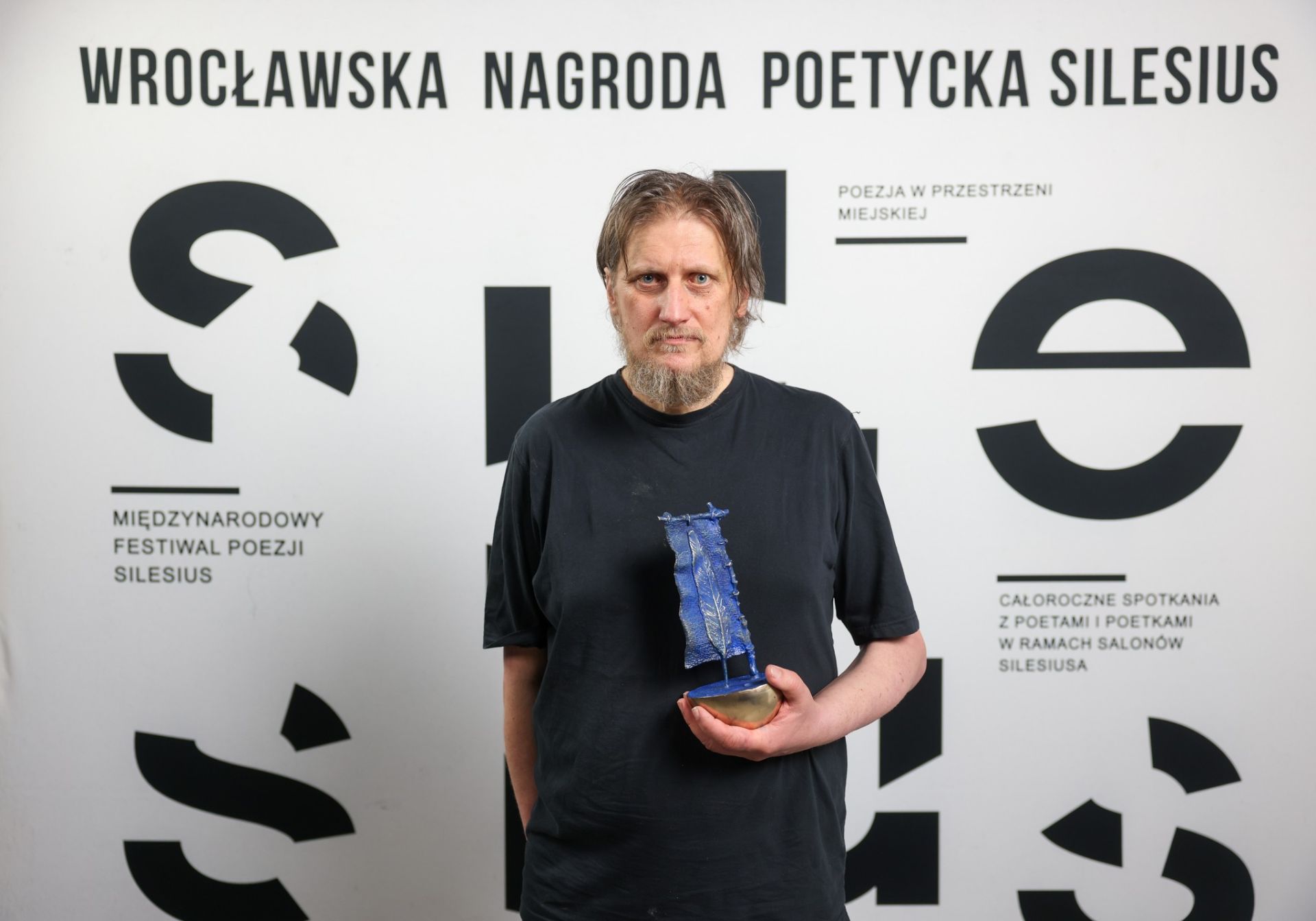 Mężczyzna trzymający w ręce statuetkę 