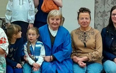 Osiem osób siedzących w rzędzie pozuje do zdjęcia