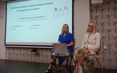 Dwie elegancko ubrane kobiety siedzą na krzesłach. Za nimi slajd prezentacji o tym, jak chronić dziecko w czasie rozstania rodziców według psychologii i prawa