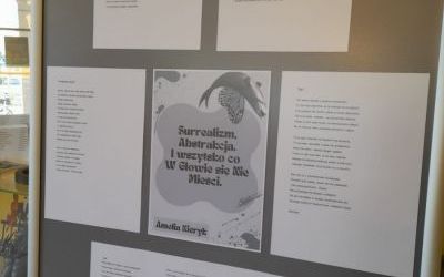 Ekspozytor z wierszami. W centralnej części karta z napisem: "Surrealizm, Abstrakcja, I wszystko co W Głowie się Nie Mieści. Amelia Kieryk"