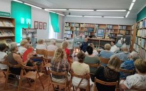 Dwaj mężczyźni siedzą na krzesłach przed widownią