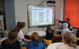 Grupa młodych osób patrzy na ekran z prezentacją