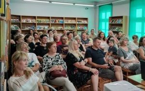Kilkadziesiąt osób siedzi na krzesłach