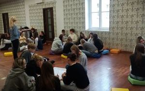 Młodzież siedzi w kilku kręgach na ziemi (4)