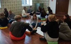 Młodzież siedzi w kilku kręgach na ziemi (3)