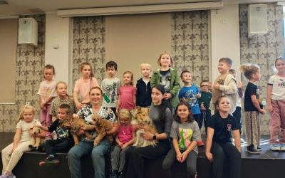 Dzieci i opiekunowie psów pozują do zdjęcia