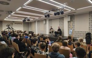 Autor Rafał Kosik i prowadzący spotkanie, przed sceną publiczność
